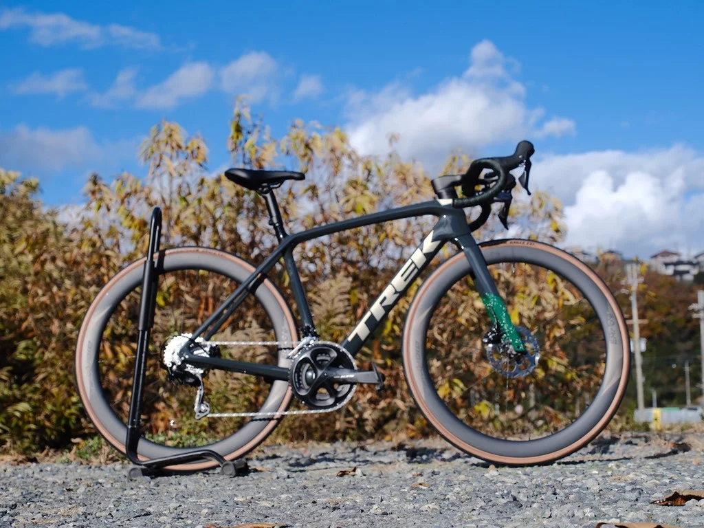 青空と木々を背景にした青い自転車
